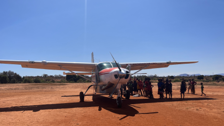 Crowd gathered around MAF plane on airstrip