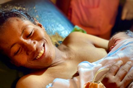 Woman smiling and holding her new born