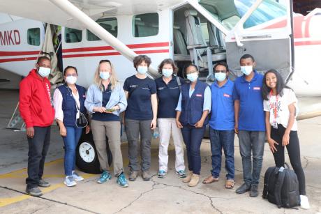 Swiss Humanitarian Aid Unit and Medair staff in front of MAF plane 5R-MKD