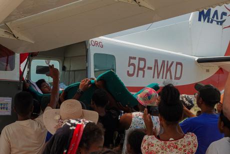 Tahiana boarding the plane with the help of people